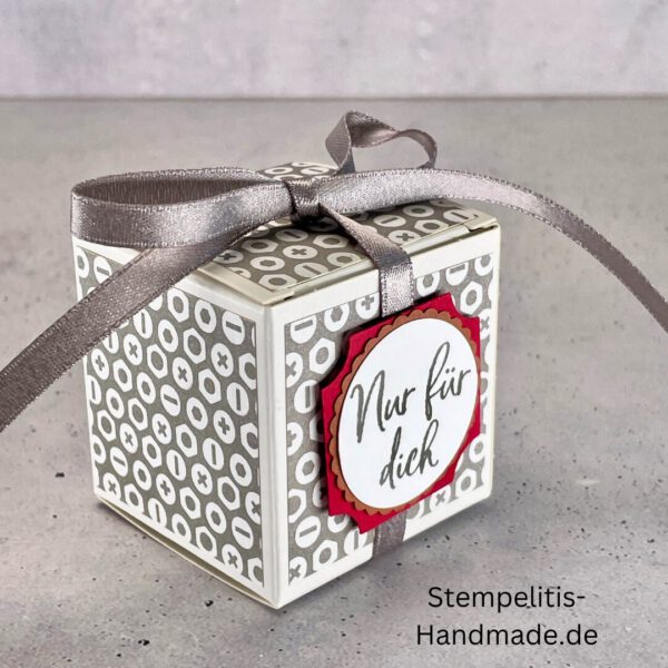 handdekorierte Geschenkschachtel mit Aufschrift „Nur für dich“, Geschenkschachtel mit grauem Muster und rotem Etikett, kleine Geschenkbox mit Satinband, Vorderansicht der Schachtel „Nur für dich“, offene Geschenkbox mit Inhalt, Detailaufnahme Schriftzug „Nur für dich“, stilvolle Geschenkverpackung mit Band